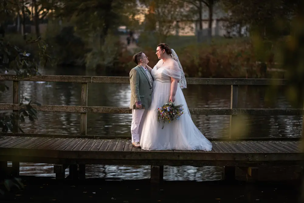 Same sex wedding photographer. Couple on bridge at sunset after Reading Town Hall wedding.