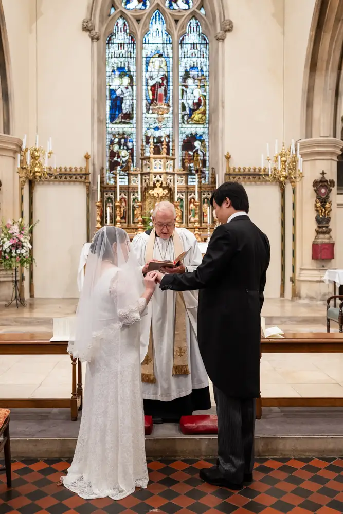 St Mary Magdalen Oxford Wedding Photographer. Bride places wedding ring on groom's finger.