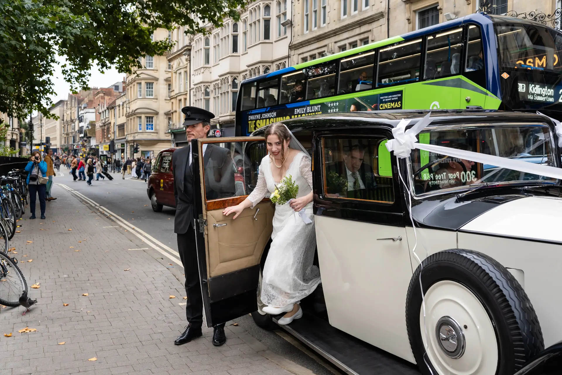 St Mary Magdalene Wedding Photographer. Bride stepping out of vintage rolls royce outside church as she arrives for wedding ceremony.