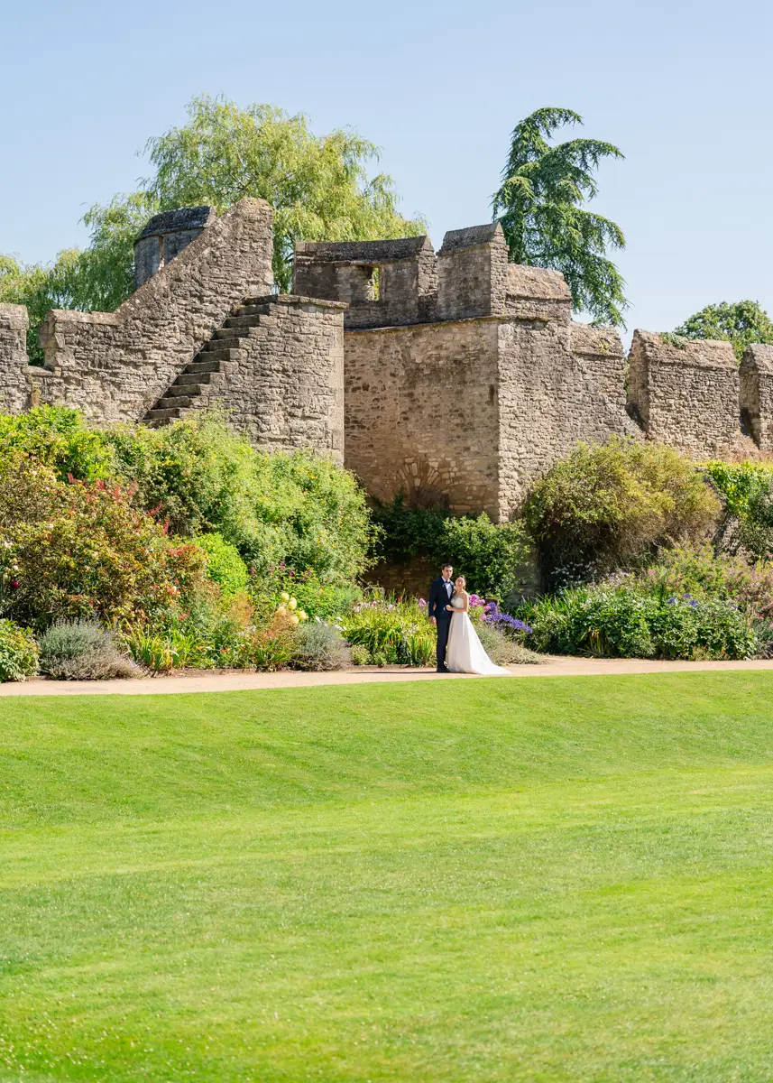 Bride and groom in gardens of New College with castle steps in background. Oxford wedding photographer.