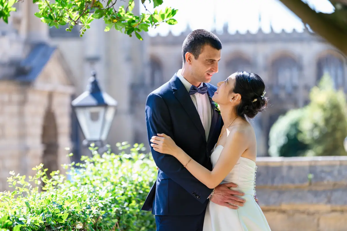 Bride and groom on platform at Exeter College with Radcliffe Camera and St mary's church in background. Oxford wedding photographer.