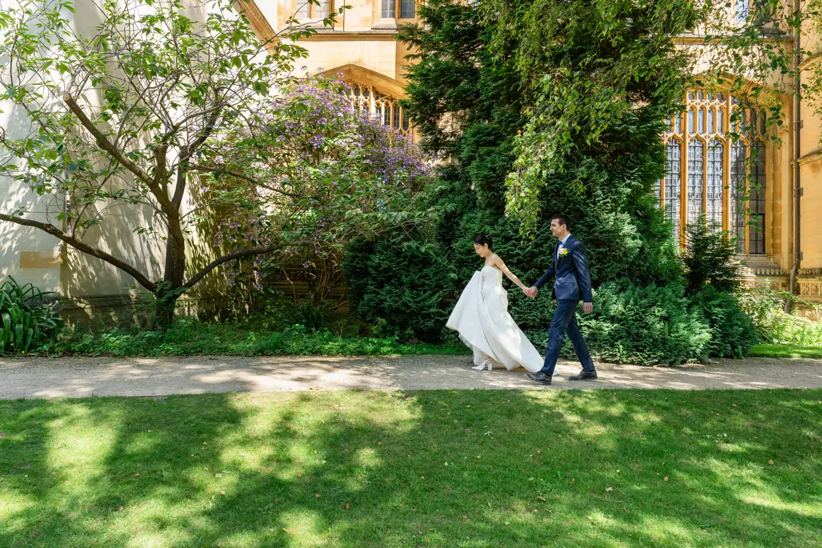Bride and groom walk in Fellows garden at Exeter College. Oxford wedding photographer.