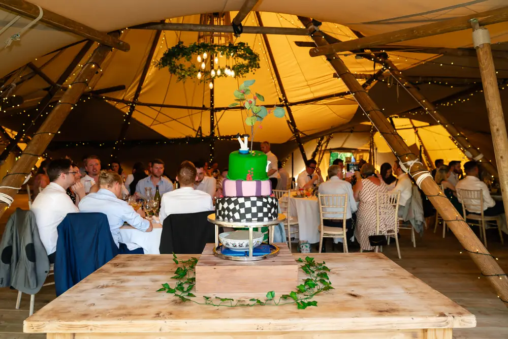 Oxfordshire Wedding Photographer. Wedding cake and guests at Dovecote Events.