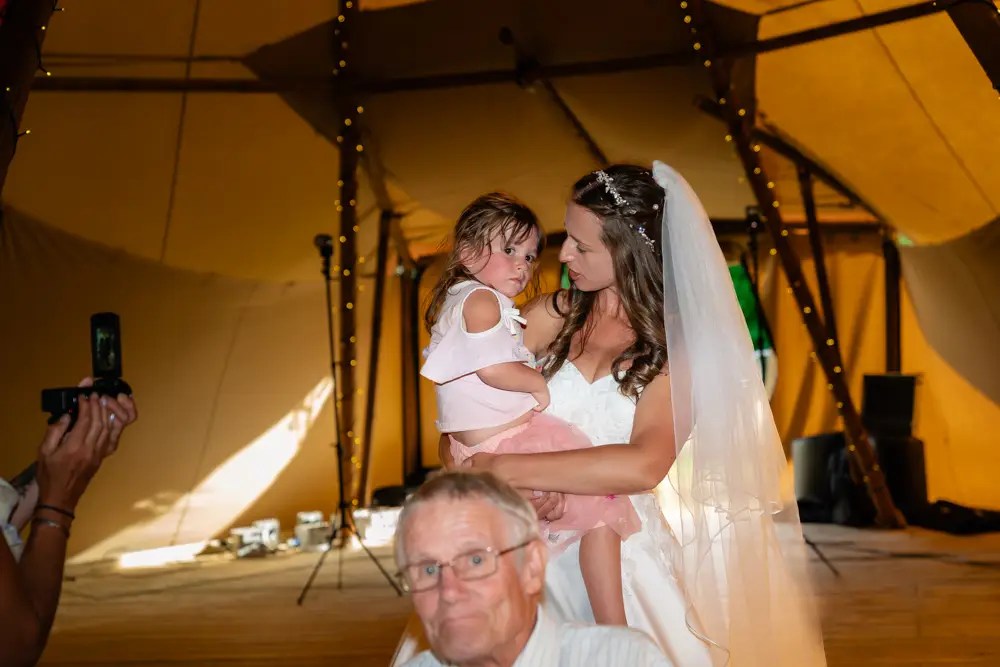 Oxfordshire Wedding Photographer. Bride with flower girl at Dovecote Events.