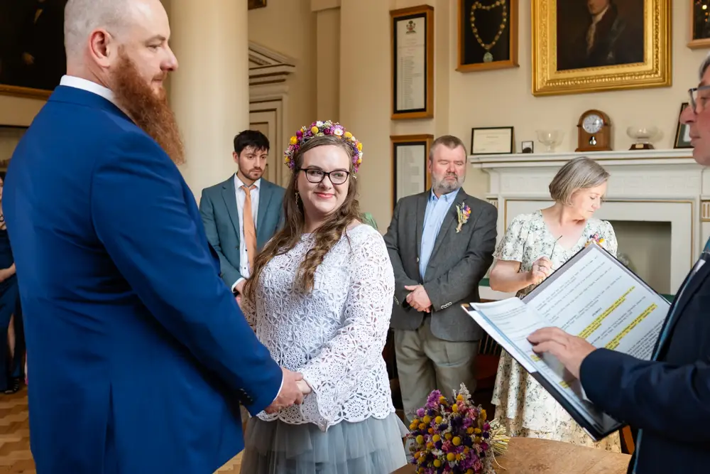 Bride and groom listen to registrar during ceremony at Woodstock Town Hall in Oxfordshire