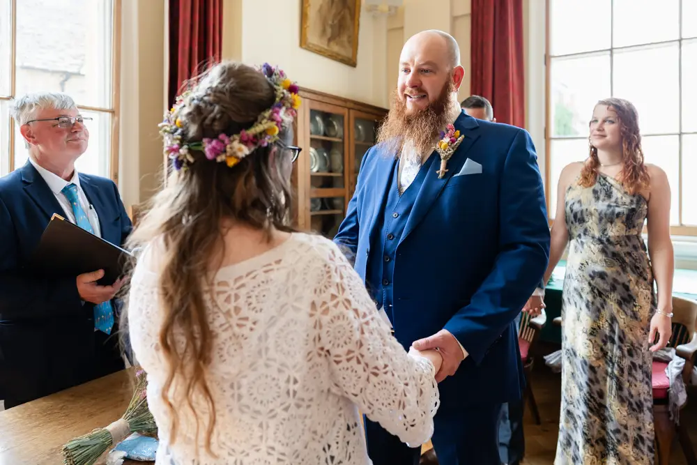 Bride and groom exchange vows during ceremony at Woodstock Town Hall in Oxfordshire