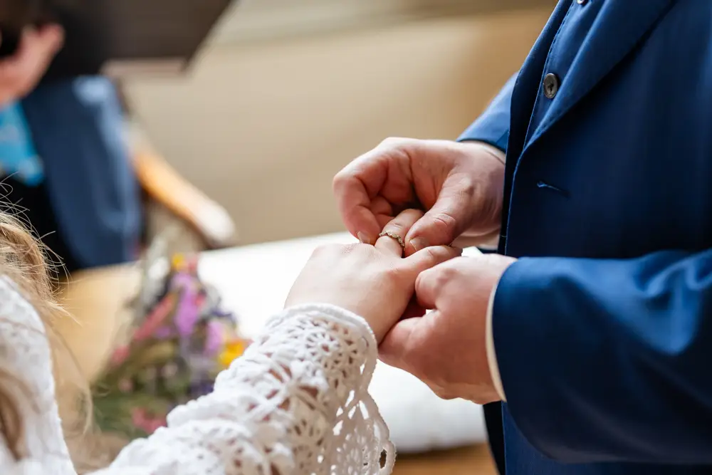 Bride and groom during ring ceremony at Woodstock Town Hall in Oxfordshire