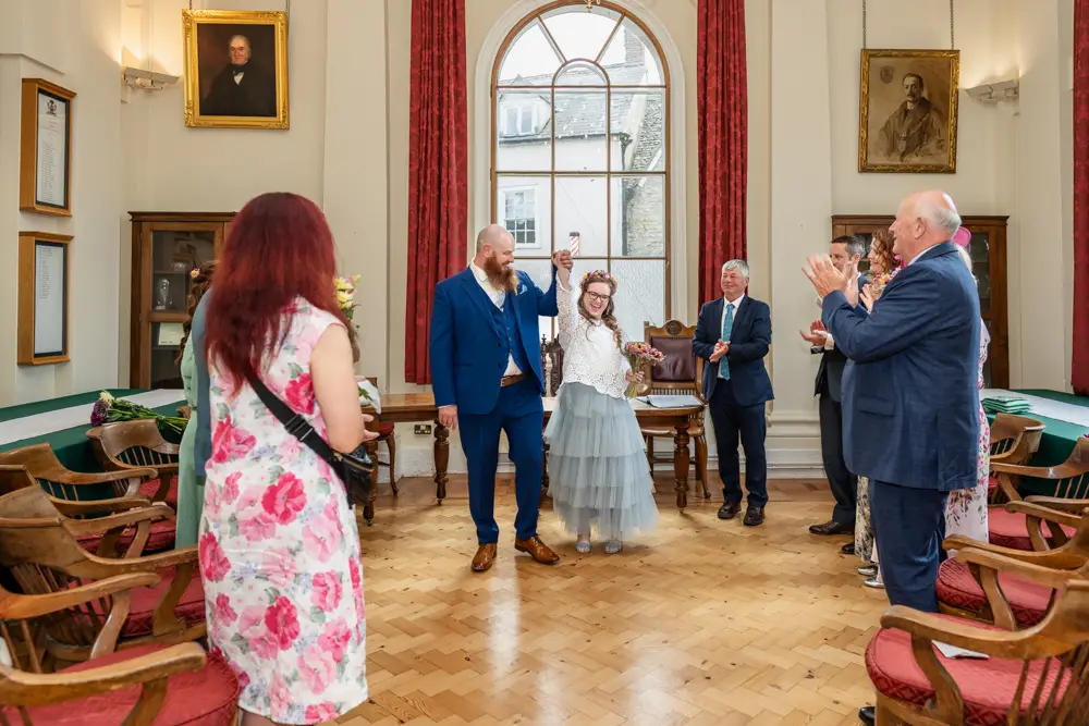 Bride and groom celebrate the end of their wedding ceremony at Woodstock Town Hall in Oxfordshire