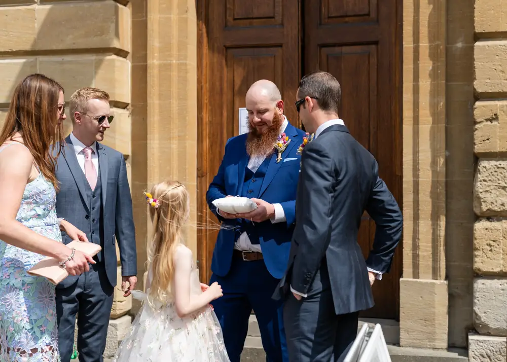 Groom holding wedding rings outside Woodstock Town Hall in Oxfordshire