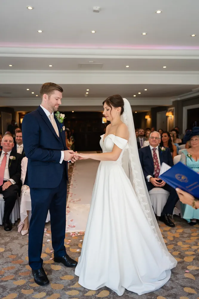 Couple exchange rings during their Bull Hotel wedding ceremony.