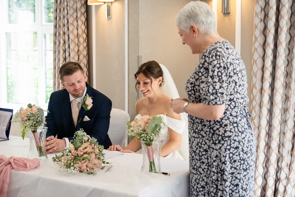Bride and groom signing register during their Bull Hotel wedding ceremony.