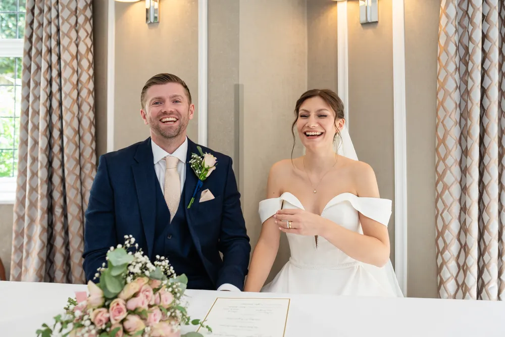 Bride and groom laugh during their Bull Hotel wedding ceremony.