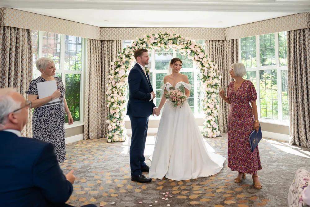 Bride and groom with registrar during their Bull Hotel wedding ceremony.