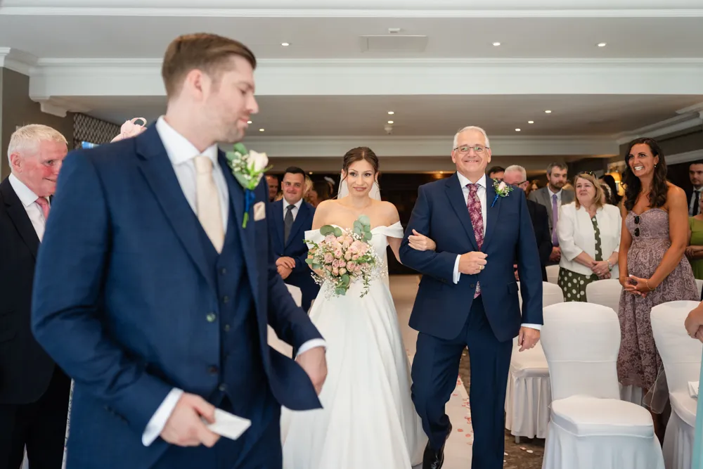 Bride walking down the aisle in Bulstrode Suite for her Bull Hotel wedding ceremony.
