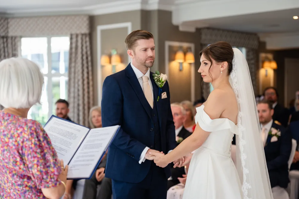 Bride and groom hold hands during their Bull Hotel wedding ceremony.