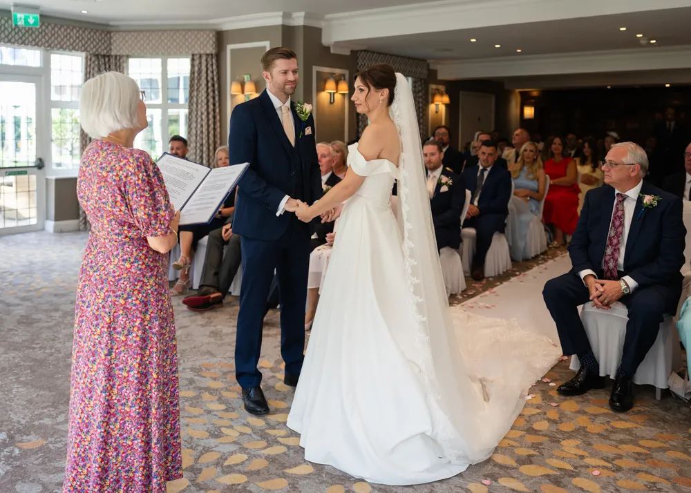 Bride and groom hold hands during their Bull Hotel wedding ceremony.