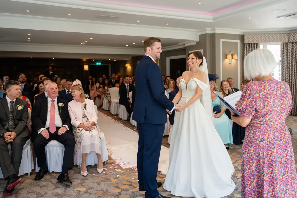 Bride and groom laughing during their Bull Hotel wedding ceremony.