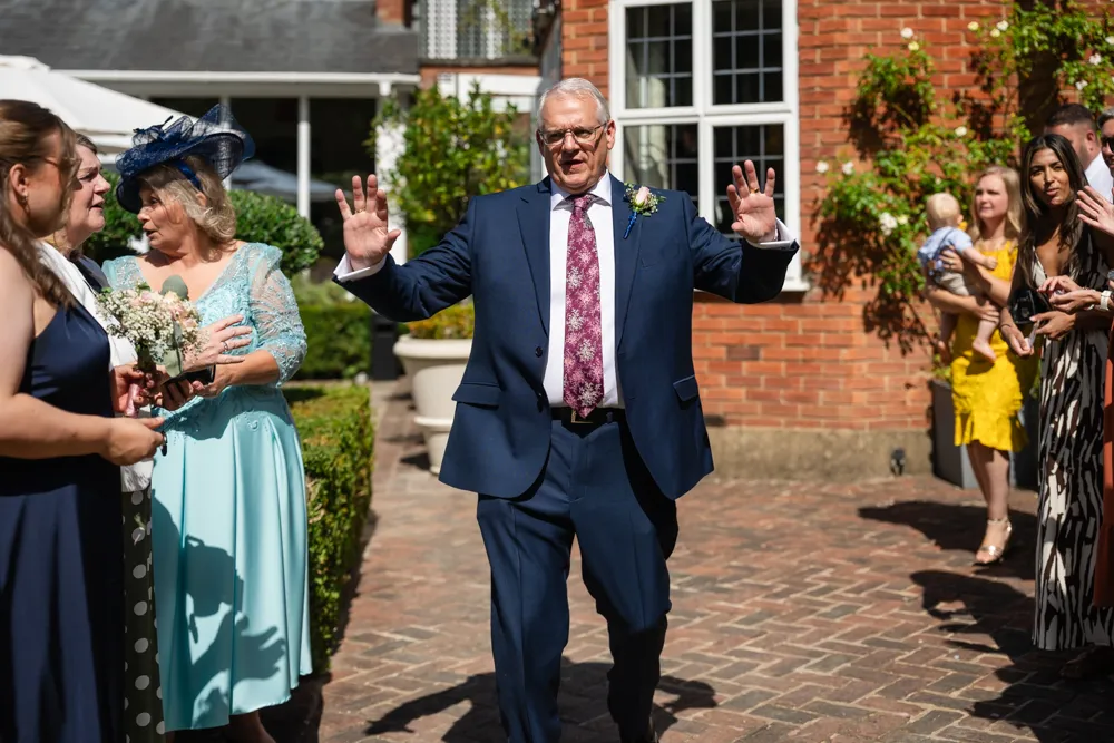 Father of bride organising guests for wedding confetti at the bull hotel.