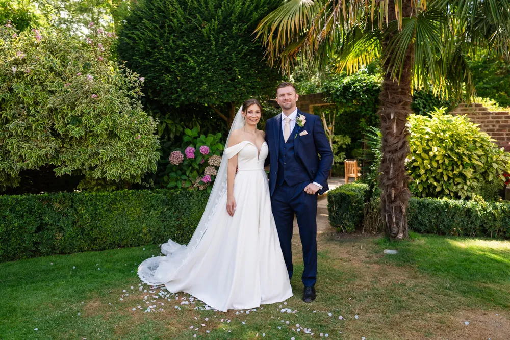 Bride and groom in gardens of Bull Hotel in Gerrards Cross.
