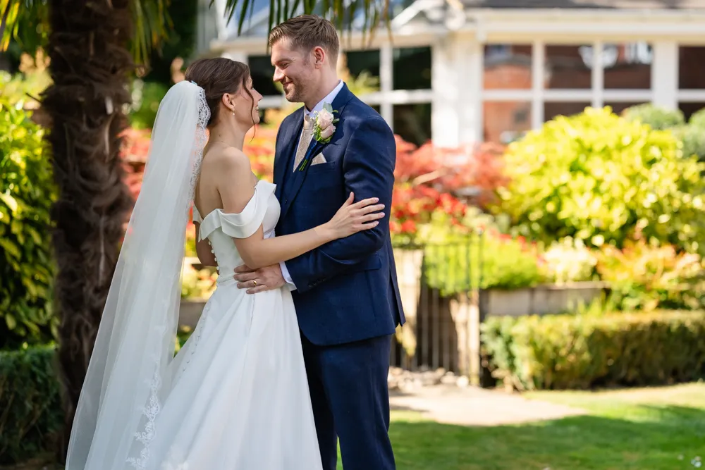 Bride and groom in gardens of Bull Hotel in Gerrards Cross.