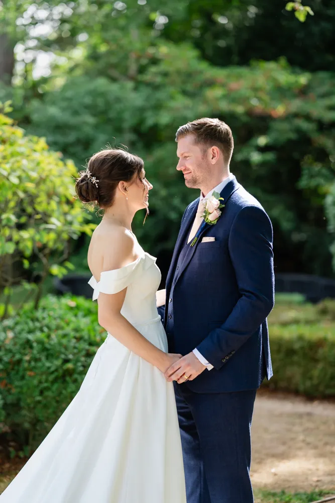 Bride and groom backlit by the sun in hotel gardens. Bull Hotel Wedding Photographer.