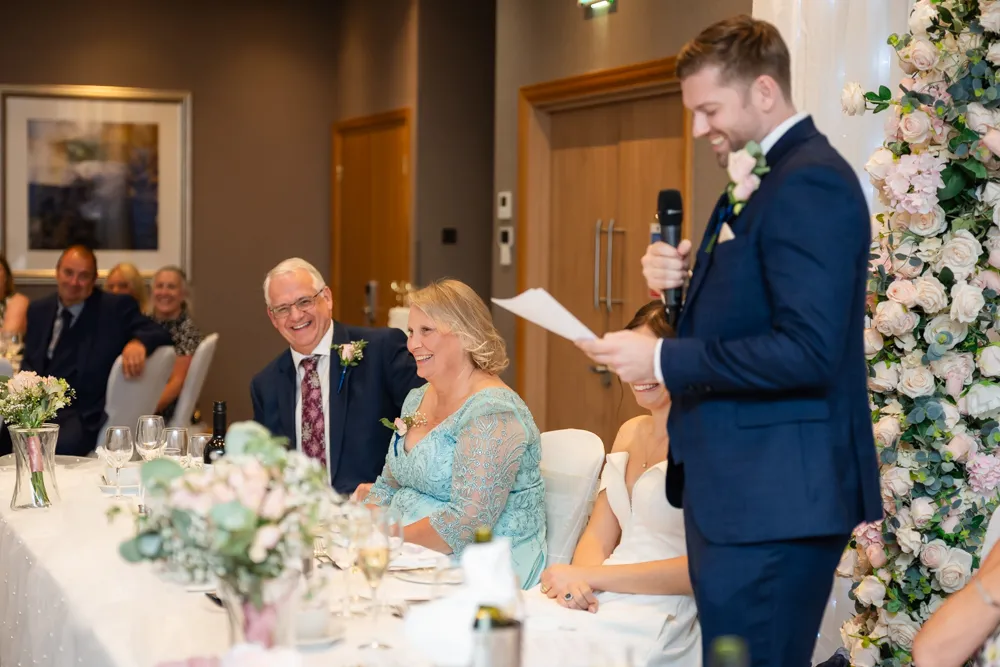 Guests laughing at the groom's speech in the Thames Suite. Bull Hotel Wedding Photographer.