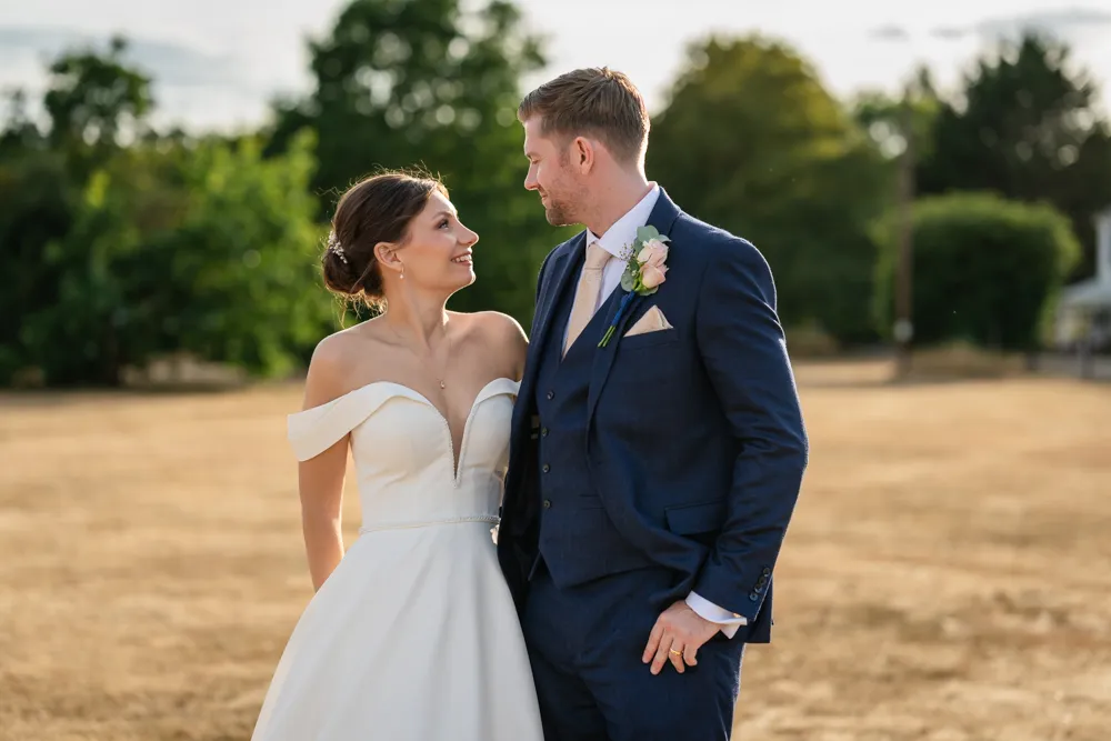 Bride and groom backlit by sun on common in Gerrards Cross. Bull Hotel Wedding Photographer.