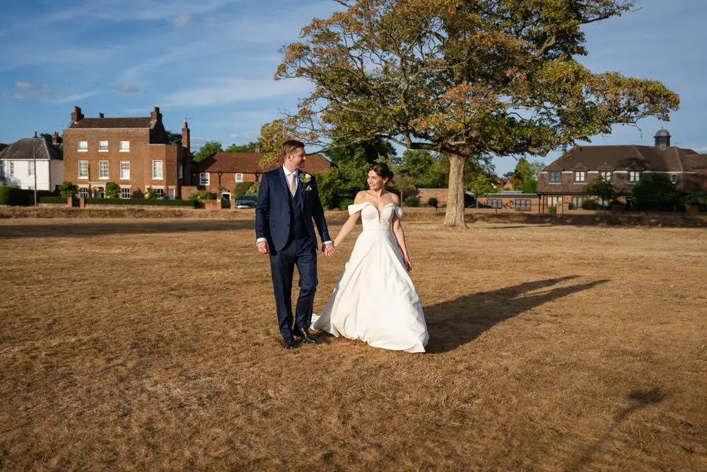 Bride and groom walking on common in Gerrards Cross. Bull Hotel Wedding Photographer.