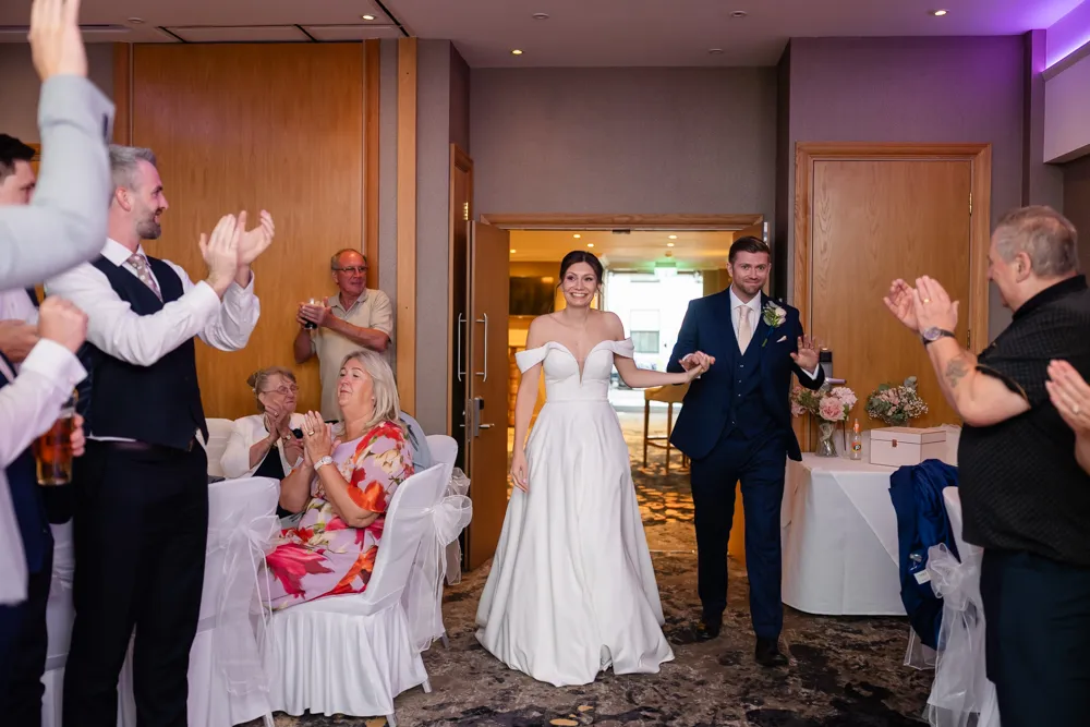 Bride and groom entering Thames Suite for cake cutting. Bull Hotel Wedding Photographer.