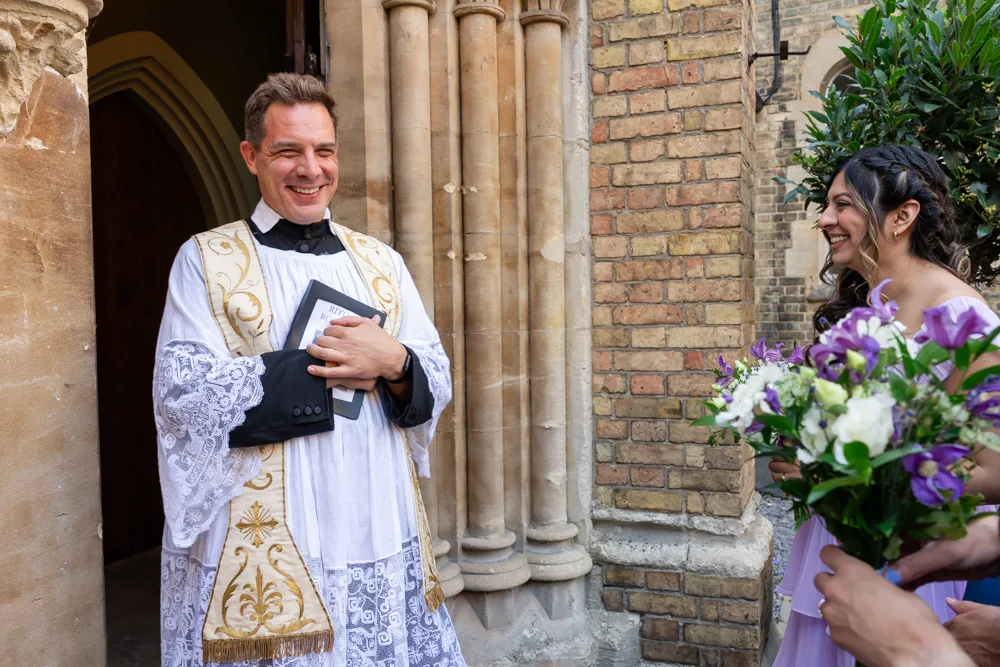 Oxford Oratory wedding photographer. Father Nicholas waits at the door for the arrival of the bride.