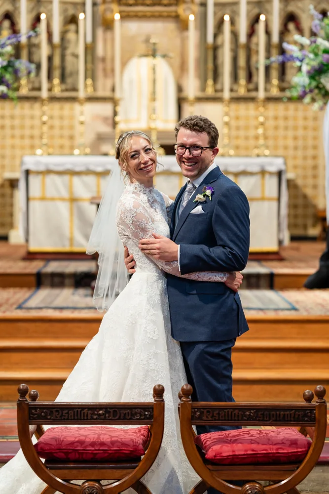 Oxford Oratory wedding photographer. Bride and groom look back at congregation after they're pronounced man and wife.