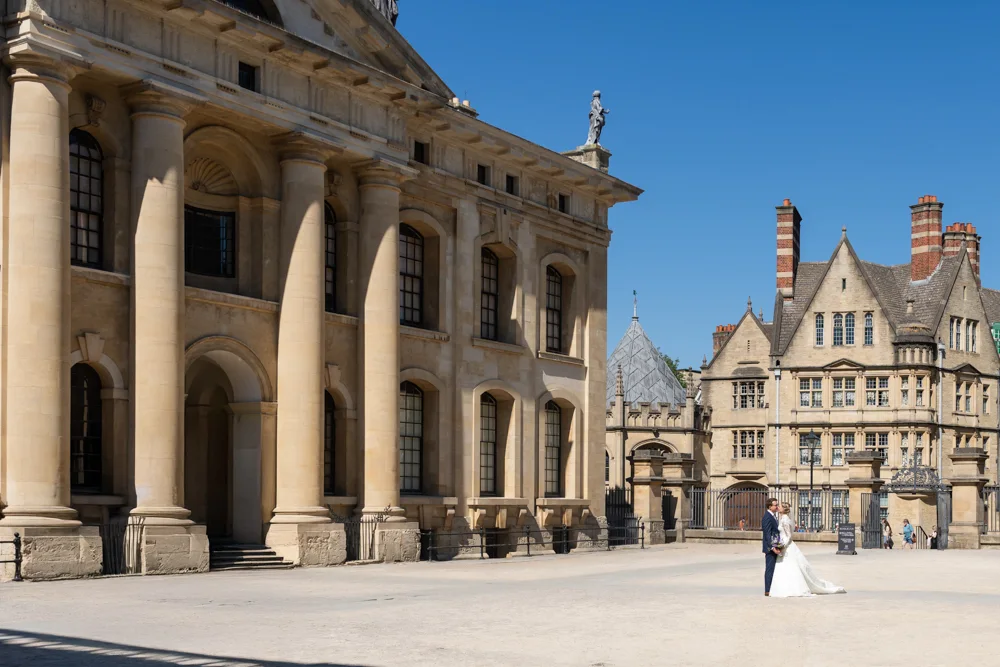 Oxford University wedding photographer with bride and groom in Clarendon Quad, Bodleian Library