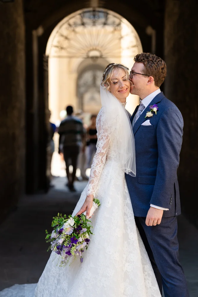 Oxford University wedding photographer. Groom kissing bride with Clarendon Building in background