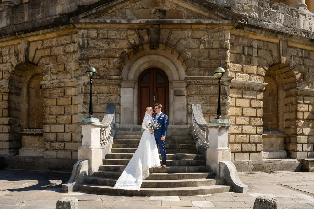 Oxford University wedding photographer. Bride and groom on steps of Radcliffe Camera.