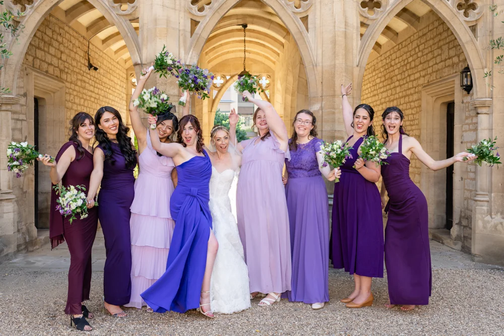 St Cross College wedding photographer. Bride and bridesmaids next to four colleges arches.
