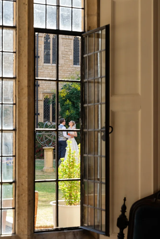 St Cross College wedding photographer. Bride and groom enjoying a quiet moment in the Blackwell Quad.