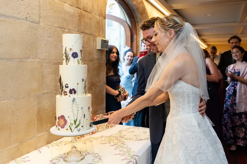 St Cross College wedding photographer. Bride and groom cutting the cake.